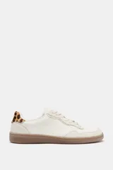 Zapatillas deportivas barefoot de color blanco con detalles en beige y suela de goma marrón. Presentan cordones blancos y detalle de estampado animal print de leopardo en la talonera.