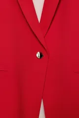 Blazer negro de cuello con solapas de muesca y hombreras, con mangas tres cuartos drapeadas, bolsillos de vivo simulados y cierre frontal con un botón dorado. Forro interior a tono.