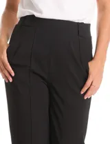 Pantalón de vestir color tostado, de corte recto y tiro alto. Presenta pretina ancha con trabas para cinturón, pinzas frontales y detalle de nervadura central a lo largo de la pierna. Cuenta con bolsillos laterales funcionales y bolsillos traseros simulados.