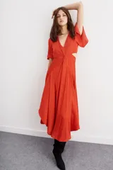 Vestido midi color ladrillo, con escote en V, mangas cortas acampanadas, nudo en la cintura y aberturas laterales.
