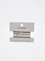 Set de tres pulseras negras de hilo con detalles dorados, que incluye un dije con símbolo de infinito, una perla sintética con dijes metálicos y una pulsera decorada con cuentas doradas.