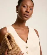 Chaleco femenino confeccionado en viscolino celeste, con escote en v, cierre por botones contrastantes y bolsillos delanteros.