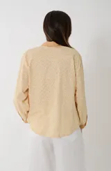 Camisa de voile de algodón estilo broderie, de color amarillo maíz con detalles en tono mostaza en el cuello, la cartera de botones y los puños. Presenta manga larga y diseño clásico con pespuntes.