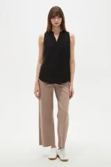 Musculosa de poliéster color negro, con cuello en V y diseño holgado sin mangas.