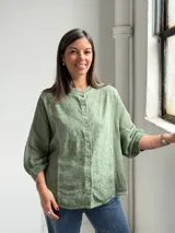 Camisa de lino verde melange, con cuello mao, mangas 3/4 y cierre frontal de botones.