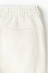 Short de lino y viscosa color beige, de corte relajado, con cintura elástica y cordón ajustable.