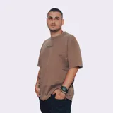 Remerón de manga corta, color marrón con efecto gastado, corte holgado y estampado frontal con texto.