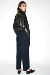 Pantalón tobillero de corte recto en color beige, con detalle de nervio delantero marcado. Incluye cinturón fino, bolsillos delanteros y cierre frontal con cremallera, botón interior y gancho.