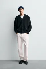 Cárdigan de hombre color negro, de corte regular fit, tejido en estructura compacta, con cuello pico, manga larga y cierre frontal de botonadura.