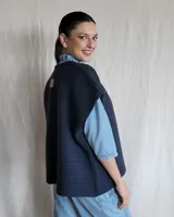 Chaleco tejido de punto color lila, sin mangas y con cuello abierto.