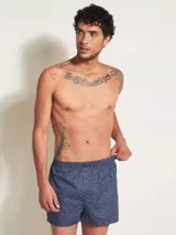 Bóxer de algodón blanco con estampado de flores pequeñas color celeste, con cintura elástica y logo de la marca en el centro.