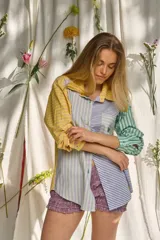 Camisa de manga larga con diseño patchwork de rayas en tonos verde, lila, amarillo y azul. Cuenta con cuello camisero, cierre frontal con botones y un bolsillo en el pecho con el logotipo bordado "pur".