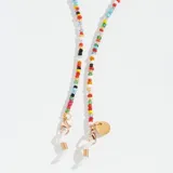 Correa para lentes con cuentas de colores y terminales dorados. Incluye un dije redondo dorado con la marca Meller grabada.