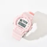 Reloj digital Q&Q color rosa con correa de silicona y pantalla con visualización de hora, fecha y día de la semana.