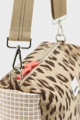 Bandolera compacta con estampado animal print tipo leopardo, correa ajustable de lona color beige y cierre superior con tirador naranja.