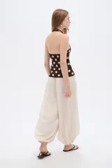 Top de punto al cuerpo con cuello halter, color beige con estampado de lunares marrones.