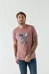Remera de hombre color rosa viejo, con cuello redondo y manga corta. Presenta un estampado central con ilustraciones de frutas cortadas, como naranjas y peras.