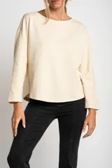 Sweater color crema de algodón peinado con cuello redondo y mangas largas.