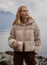 Campera puffer beige con cuello alto acanalado, cierre frontal con cremallera y bolsillos laterales.