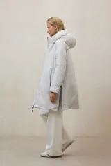 Campera larga acolchada color verde oliva, con capucha grande y cierre frontal de cremallera negra.