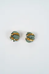 Aros de diseño circular con estructura metálica dorada y capas de tela en color verde musgo, creando un efecto de volumen y textura.