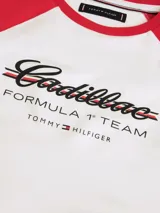 Remera de corte slim con mangas raglán a contraste en color rojo. Presenta estampado frontal con logo de Cadillac en fuente script y detalles de la colaboración con Formula 1 Team. Confeccionada en algodón elástico con cuello redondo.