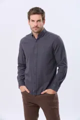 Camisa de manga larga color gris oscuro, con efecto lavado, cuello camisero con botones y cierre frontal abotonado.