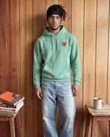 Buzo canguro con capucha color verde, de corte regular, con estampa central en la espalda de Astroboy volando y texto pequeño.