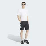 Short Adidas Adicolor Double Blocked de color negro, confeccionado en tejido ripstop. Presenta un diseño holgado, bolsillos laterales, cierre de cremallera, el logo del Trifolio bordado y detalles gráficos de franjas blancas en el lateral.