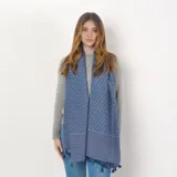 Pashmina rectangular de acrílico color azul con estampado geométrico en blanco y flecos en los extremos.