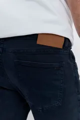 Pantalón de jean corte regular, color azul oscuro, con cierre de botón y cremallera, y bolsillos laterales y traseros.