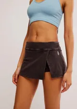 Short pollera deportivo color marrón con efecto lavado, cintura elástica y logo estampado en la parte delantera.