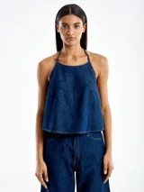 Top de jean azul con cuello halter y espalda descubierta.