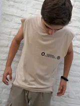 Musculosa de color beige con cuello redondo y corte holgado. Presenta un estampado minimalista en negro en el lateral del pecho con el nombre de la marca Osten Studio y coordenadas geográficas.