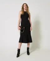 Vestido midi negro sin mangas confeccionado en mezcla de viscosa elástica Milano, con cuello halter, cintura entallada, falda acampanada, costuras verticales, forro y placa con logo Oval T en la espalda.