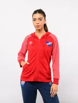 Campera deportiva Umbro del Club Nacional de Football, modelo Aura para mujer. Diseño con capucha, cierre frontal completo y bolsillos laterales. Presenta cuerpo en color rojo con mangas en un tono de rojo jaspeado, detalles tricolor en los hombros y escudo del club bordado en el pecho.