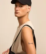 Musculosa básica de hombre, color blanco, con cuello redondo, sin mangas y pequeña etiqueta aplicada en el bajo.