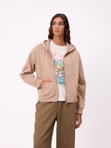 Canguro con cierre frontal y capucha, color gris con efecto desgastado. Presenta bolsillos laterales y logo bordado en el pecho.