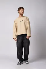 Buzo de cuello redondo confeccionado en tejido rústico, con diseño boxy, costuras a la vista y bordes al corte. Presenta estampas en el frente, la espalda y el interior, permitiendo un uso reversible.