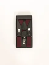 Tiradores color bordó con detalles de cuero negro y broches metálicos plateados, presentados en una caja negra.