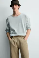 Camiseta de manga larga con ajuste relaxed fit y cuello redondo amplio, confeccionada en tejido de mezcla de algodón y lino con patrón de rayas horizontales en color verde y blanco.
