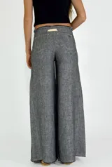 Pantalón de lino color ladrillo, de corte palazzo y tiro alto, con bolsillos laterales y cordón ajustable en la cintura.