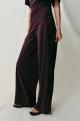 Pantalón largo color bordó, confeccionado en crepe fluido, con tiro alto, cintura elástica y diseño de pierna ancha.