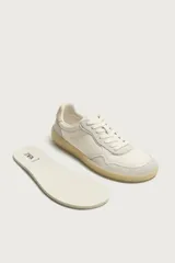 Zapatilla deportiva estilo barefoot fabricada en piel. Presenta un diseño de paneles combinados, puntera redondeada y ancha para mayor libertad de movimiento, plantilla OrthoLite extraíble y suela de goma fina en contraste.