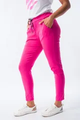 Pantalón babucha fucsia de corte amplio, con cintura elástica ajustable con cordón y bolsillos laterales.