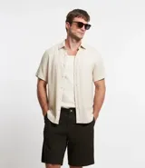 Bermuda de sarga color blanco, de corte recto y diseño básico con bolsillos laterales y traseros.