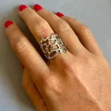 Anillo plateado con diseño de red irregular y tamaño regulable.