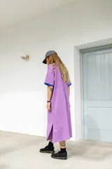 Vestido largo marrón con cuello redondo y mangas cortas con ribete amarillo. Estampado frontal con letras en color crema.