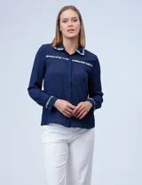 Camisa azul de gasa con cuello, delantera y puños con apliques de pasamanería.
