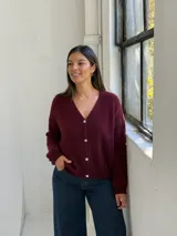 Saco tipo cardigan de punto, color bordó, con escote en V y cierre frontal de botones. Presenta mangas largas con puños acanalados y un diseño de calce holgado.